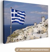 Canvas Schilderij Vlag Griekenland bij een dorp - 60x40 cm - Wanddecoratie