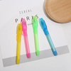 Vier onzichtbare inkten pennen in geel, roze, groen en blauw liggen op een vel papier.