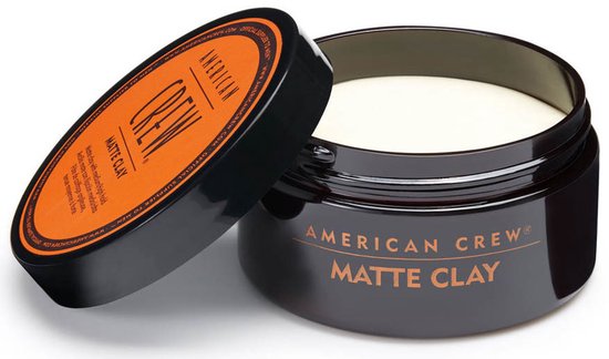 Zwarte pot American Crew Matte Clay met open deksel. De inhoud is wit.