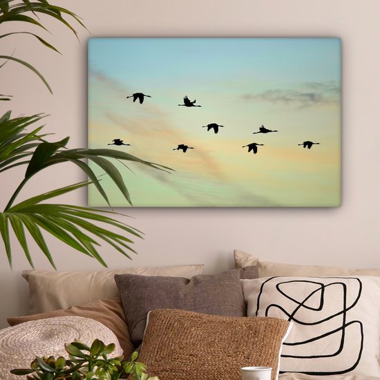 Tableau sur toile Un ciel bleu-jaune avec huit grues - 90x60 cm - Décoration murale