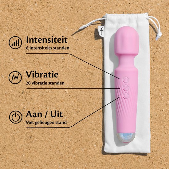 Vibrateur rose avec fonctions 'Intensité', 'Vibration', 'Marche / Arrêt'. Posé sur du sable avec une pochette blanche.