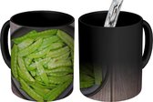 Magische Mok - Foto op Warmte Mok - Peultjes in een zwarte kom op een houten ondergrond - 350 ML