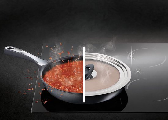 Koekenpan met rode saus op een inductiekookplaat, deels afgedekt door een zilverkleurig deksel met glazen venster.
