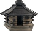 Vogelhuisje met blokhutstructuur en donker houten dak en schoorsteen.