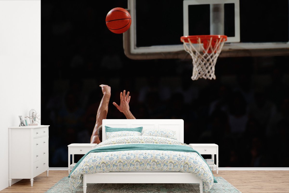 Behang - Fotobehang Basketbalspeler schiet van ver de bal in de basket - Breedte 390 cm x hoogte 260 cm