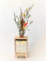 Houten decoratie met licht en droogbloem boeketje in glasbuisje