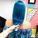 Vrouw met lang, glanzend, fel blauw haar.