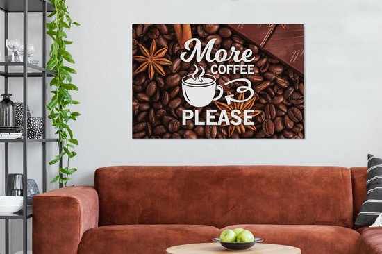 Canvasdoek met de tekst 'More coffee please' tussen koffiebonen, steranijs, kaneelstokje en stukken chocolade, boven een bruine bank.