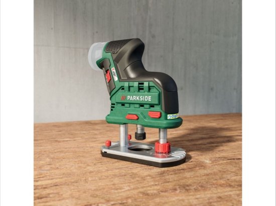 Groene en zwarte Parkside accuschroefmachine met metalen voet en rode instelknoppen op een houten ondergrond.