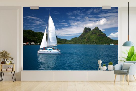 Behang - Fotobehang Zeilboot vaart langs de groene kust - Breedte 390 cm x hoogte 260 cm