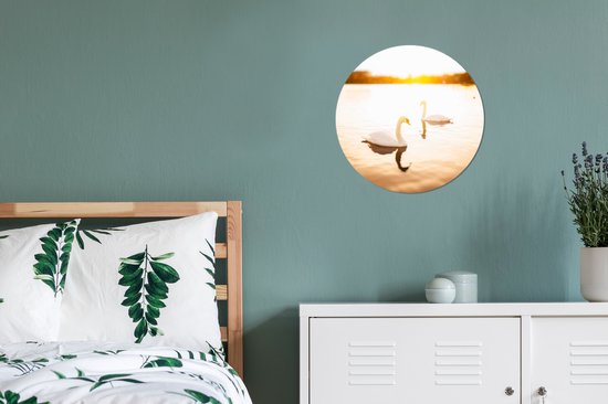 Deux cygnes nagent dans l'eau pendant un coucher de soleil lumineux Assiette en plastique cercle mural Ø 30 cm - impression photo sur cercle mural / cercle vivant (décoration murale)