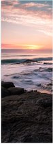 Poster Glanzend – Zonsondergang - Zee - Rotsen - Stenen - Water - Schuim - Golven - 30x90 cm Foto op Posterpapier met Glanzende Afwerking
