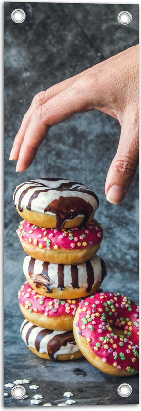 Tuinposter – Donuts - Gestapeld - Sprinkels - Hand - Kleurrijk - 20x60 cm Foto op Tuinposter (wanddecoratie voor buiten en binnen)