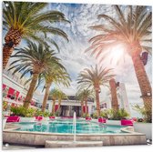 Tuinposter – Zwembad - Bomen - Palmbomen - Bedjes - Roze - Hotel - Gebouw - Zon - Tropisch - 100x100 cm Foto op Tuinposter (wanddecoratie voor buiten en binnen)