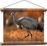 Textielposter - Kraan vogel loopt door natuur gebied heen met zijn groep op de achtergrond - 40x30 cm Foto op Textiel
