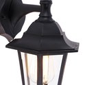 Detail van de zwarte wandlamp met glazen panelen en zichtbare gloeilamp.