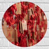 Muursticker Cirkel - Rode Sleutelhangers met Chinese Tekens aan een Muur - 40x40 cm Foto op Muursticker