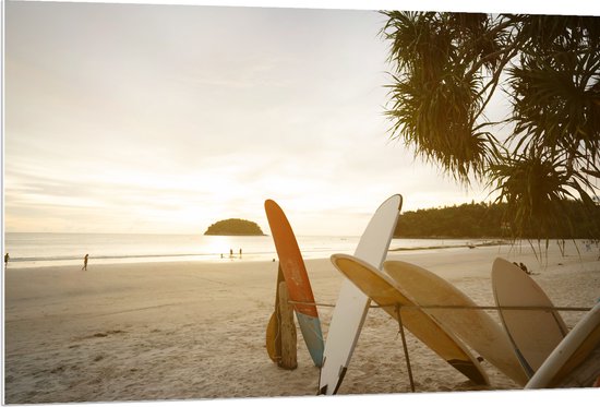 PVC Schuimplaat- Rij Surfplanken op het Strand tijdens Avondzon - 120x80 cm Foto op PVC Schuimplaat