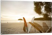 Tuinposter – Rij Surfplanken op het Strand tijdens Avondzon - 150x100 cm Foto op Tuinposter (wanddecoratie voor buiten en binnen)