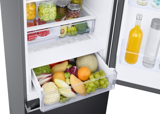 Gevulde lade met diverse verse groenten en fruit in een open Samsung koelkast.