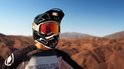 Motorcrosshelm met rode goggle en camera, gedragen door persoon met Endura shirt.