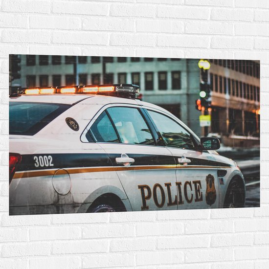 Muursticker - Politie Auto rijdend door de Stad - 120x80 cm Foto op Muursticker