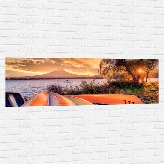 Muursticker - Oranje Kano's op zijn Kop aan het Water tijdens Zonsondergang - 150x50 cm Foto op Muursticker