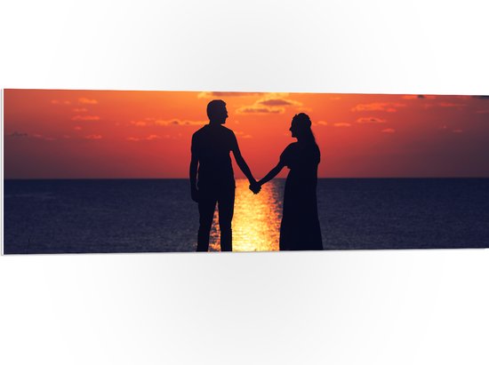 PVC Schuimplaat - Silhouet van Koppel Hand in Hand bij de Zee tijdens Zonsondergang - 120x40 cm Foto op PVC Schuimplaat (Met Ophangsysteem)
