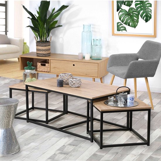 Vue de tables basses avec plateau en bois et cadre noir, décorées d'accessoires de maison.