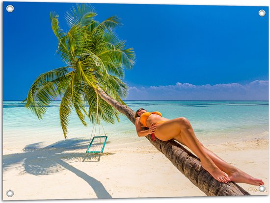 Tuinposter – Vrouw in Gele Bikini Liggend op Schuingroeiende Palmboom op Tropisch Strand - 80x60 cm Foto op Tuinposter (wanddecoratie voor buiten en binnen)