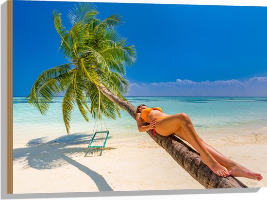 Hout - Vrouw in Gele Bikini Liggend op Schuingroeiende Palmboom op Tropisch Strand - 80x60 cm - 9 mm dik - Foto op Hout (Met Ophangsysteem)
