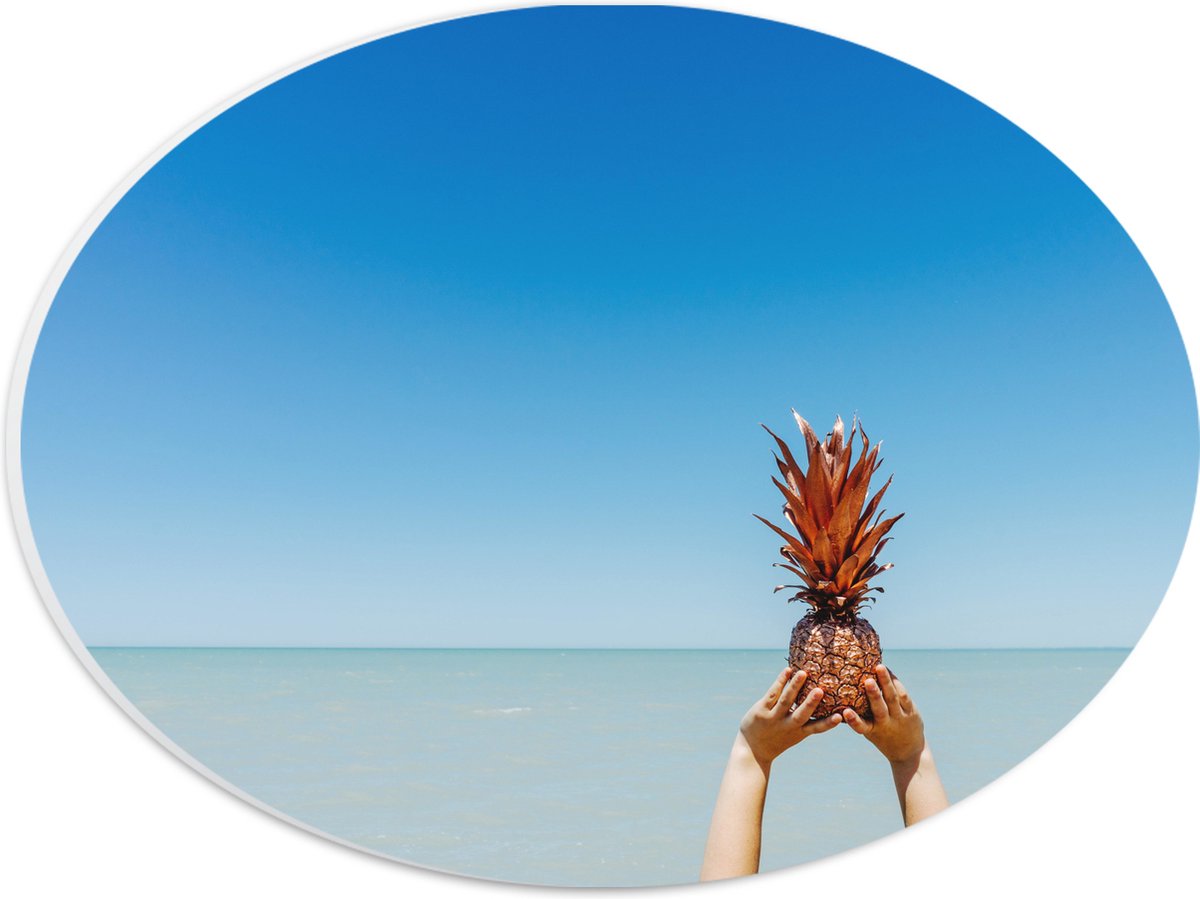 PVC Schuimplaat Ovaal - Ananas in Handen bij het Water - 28x21 cm Foto op Ovaal (Met Ophangsysteem)