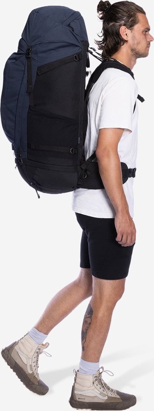 Man met blauwe Nomad rugzak, zwart heupband, wandelend.