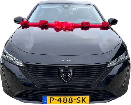 Zwarte auto met rode strik en rozen op de motorkap.