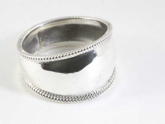 Large bague argentée avec un centre poli et des bords décoratifs en câble.