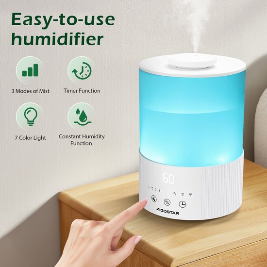 Een vinger raakt het bedieningspaneel van een witte luchtbevochtiger aan die blauw verlicht is, met iconen voor mist, timer, kleur en constante vochtigheid.