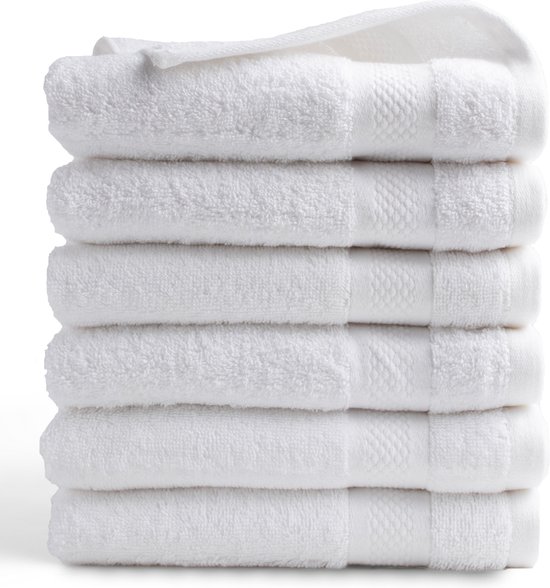 Stapel witte handdoeken met een gedetailleerde textuur.