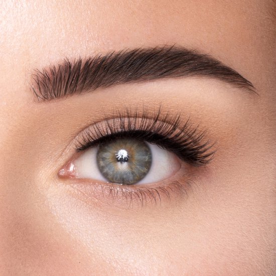 Close-up van een oog met lange, volle en natuurlijke nepwimpers. De ogen hebben blauwgroene irissen en een strakke wenkbrauw.