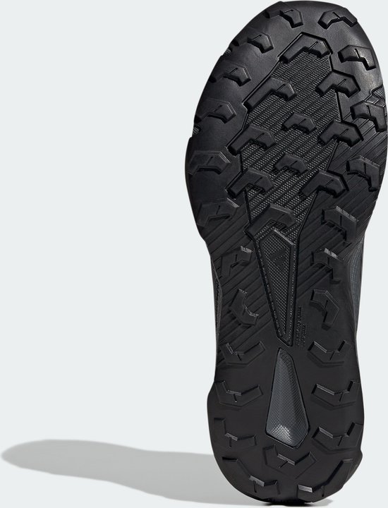 Onderkant van een zwarte Adidas Terrex trailrunningschoen met een grof profiel.