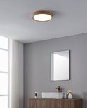 Ronde houtlook plafondlamp in een moderne badkamer boven een wastafel.
