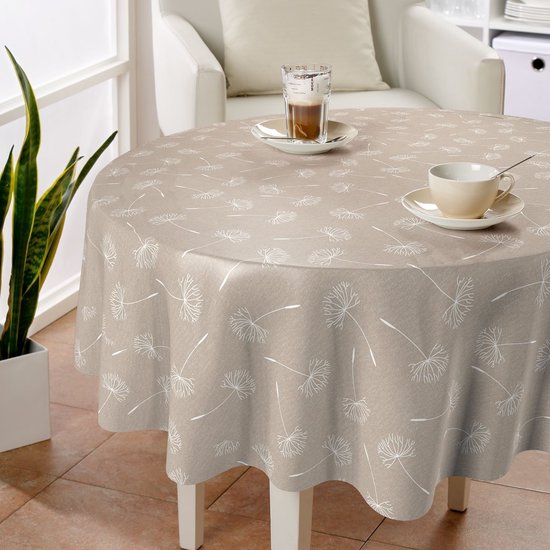 Nappe ronde beige avec imprimé de graines de pissenlit, dressée avec une tasse de café et un verre.