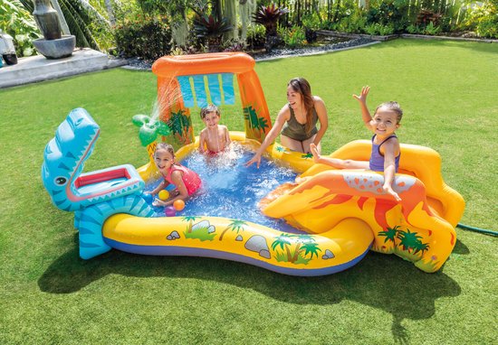Gezin met kinderen spelen in opblaasbaar dinosaurus zwembad in de tuin.
