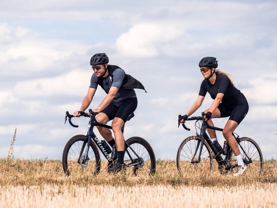 Man en vrouw fietsen door een droog veld.