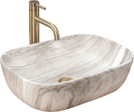 Lavabo ovale aspect marbre avec robinetterie dorée.