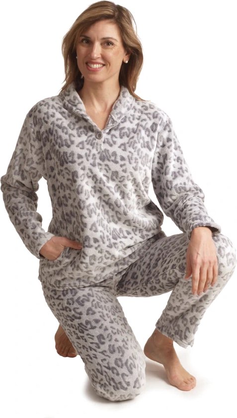 Een vrouw in een grijs panterprint fleece pyjama, knielend met een hand in de zak.