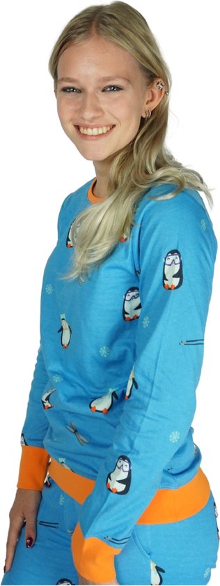 Model in een blauw pyjamapak met pinguïnprint en oranje boorden, lachend.