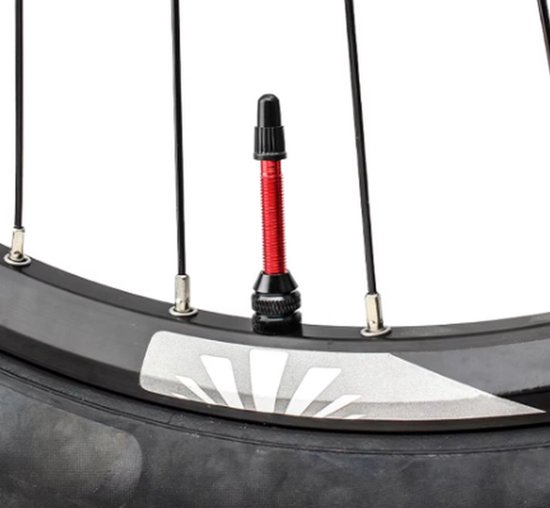 Rode presta ventiel op een fietswiel met zwarte spaken en een wit logo.