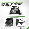 Zichtbare mechaniek van de zwarte hometrainer, met focus op de antislipvoeten en de verstelbare riem om aan stoelen te bevestigen.