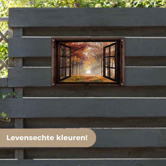 Une affiche de jardin avec une fenêtre ouverte sur une forêt d'automne est accrochée à une clôture sombre.