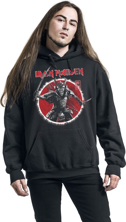 Man met lange haren draagt zwarte hoodie met opdruk krijger met katana's en 'Iron Maiden' logo.